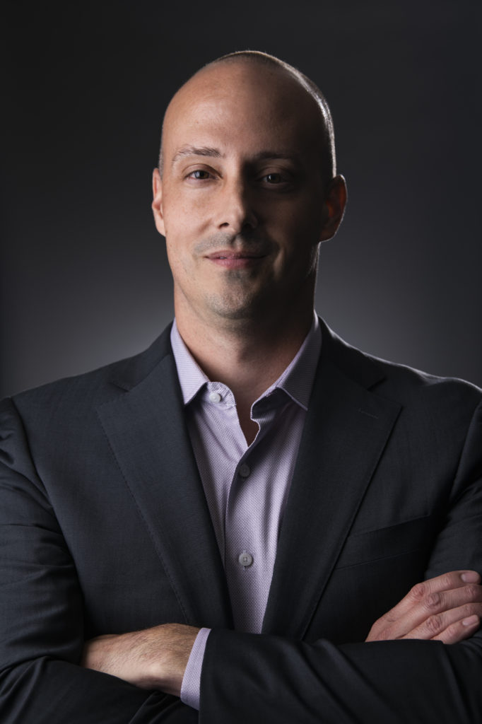 A MegaPlanIT team member wearing a nice button up shirt and suit jacket.