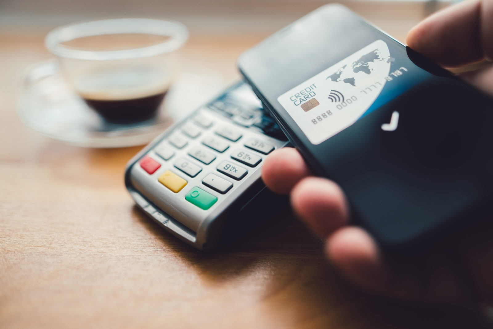 A person paying by credit card in a restaurant using a POS machine.