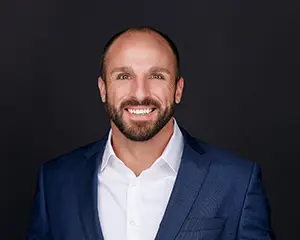 Jerry Abowd, VP OF SALES & MARKETING with MegaplanIT in a blue suit with a white button up dress shirt, smiling for the camera, representing the management team.